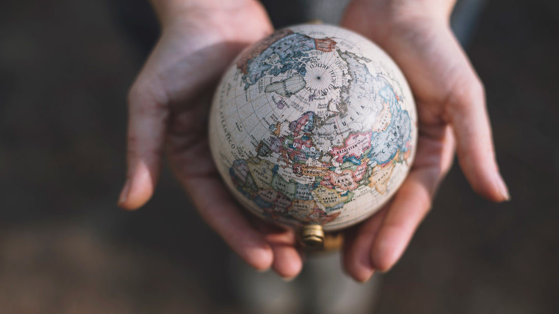 Hands holding a miniature globe to represent how to Future Proof Your Compliance